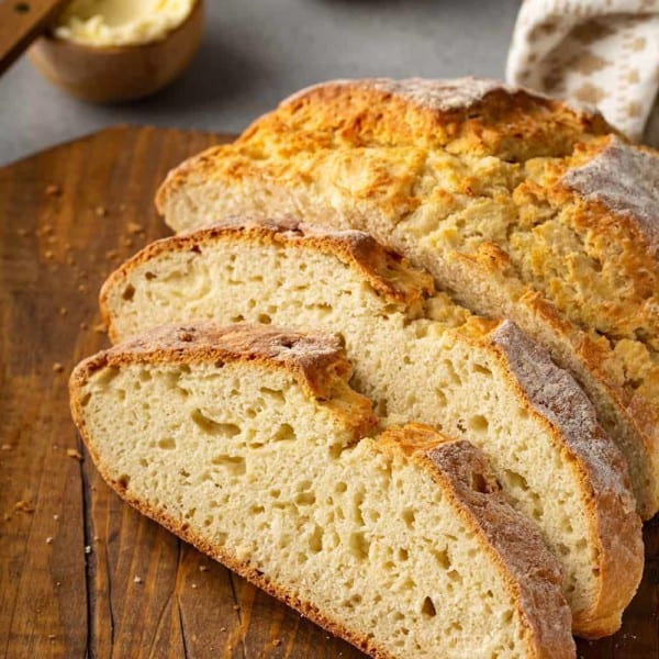 Sliced loaf of irish soda bread on a wooden cutting board