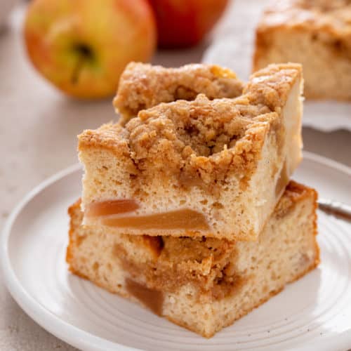 Two slices of easy apple coffee cake stacked on a white plate.