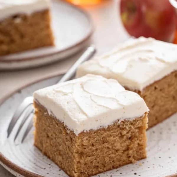 Close up view of 2 slices of apple butter cake on a stoneware plate.