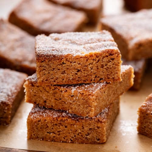 Stacked apple cider blondies on parchment.