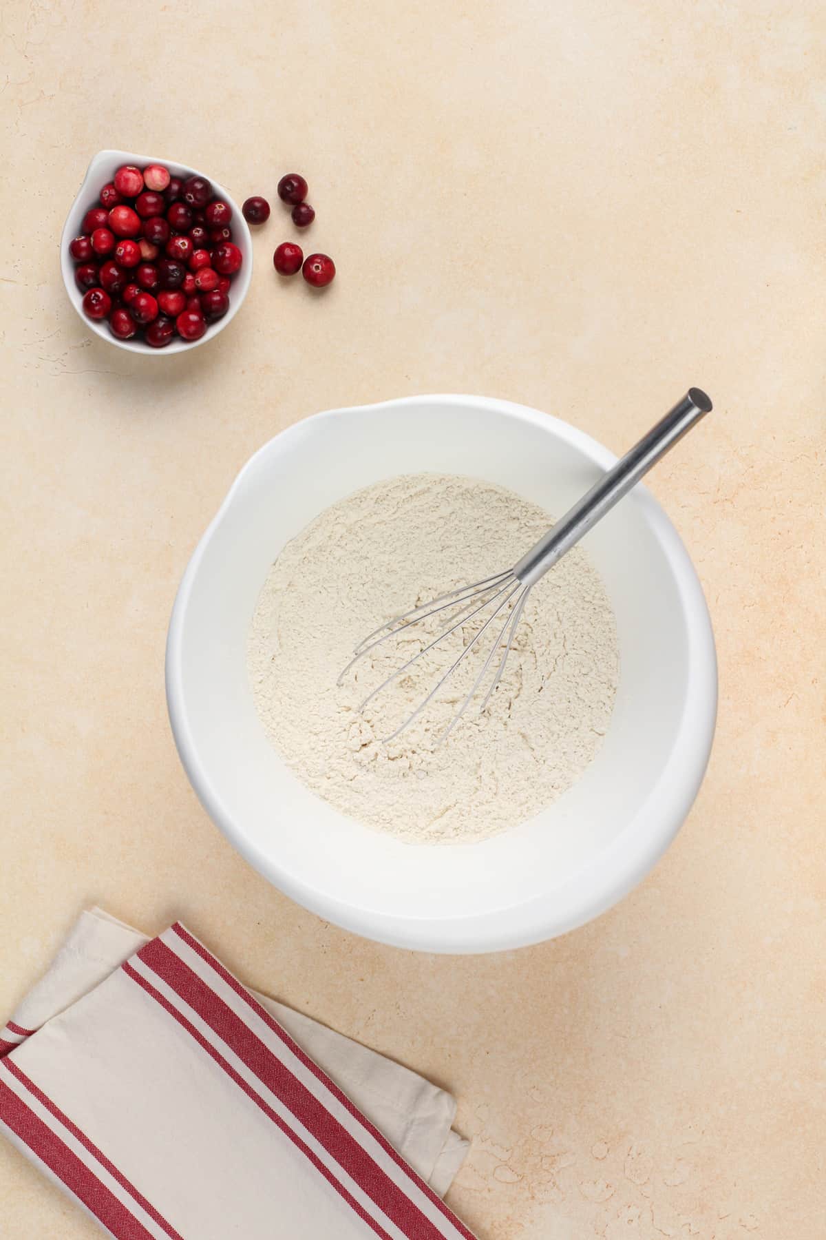 The dry ingredients for the muffins are whisked into a white bowl.