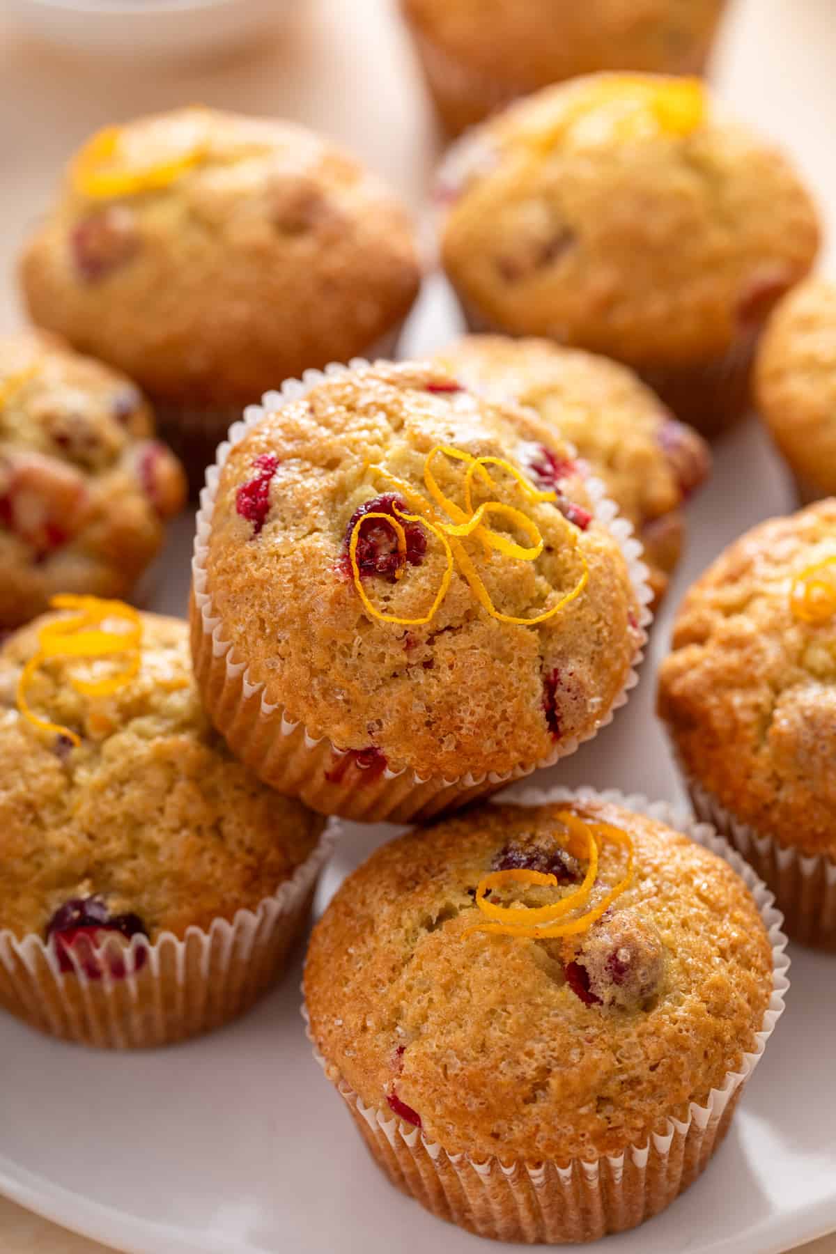 Close up of cranberry muffins arranged on a white plate.