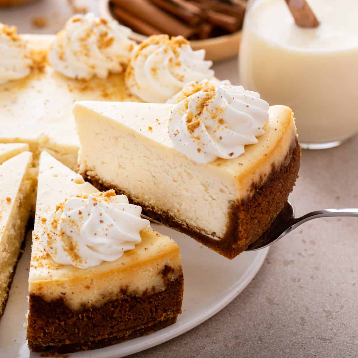 https://www.mybakingaddiction.com/wp-content/uploads/2023/12/serving-eggnog-cheesecake-hero.jpg