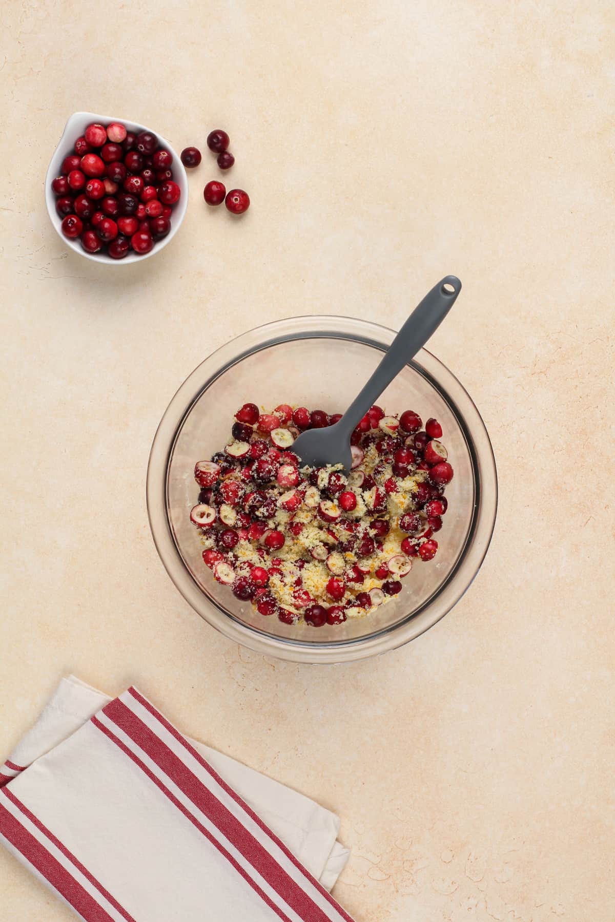 Chopped fresh cranberries topped with sugar in a glass bowl.