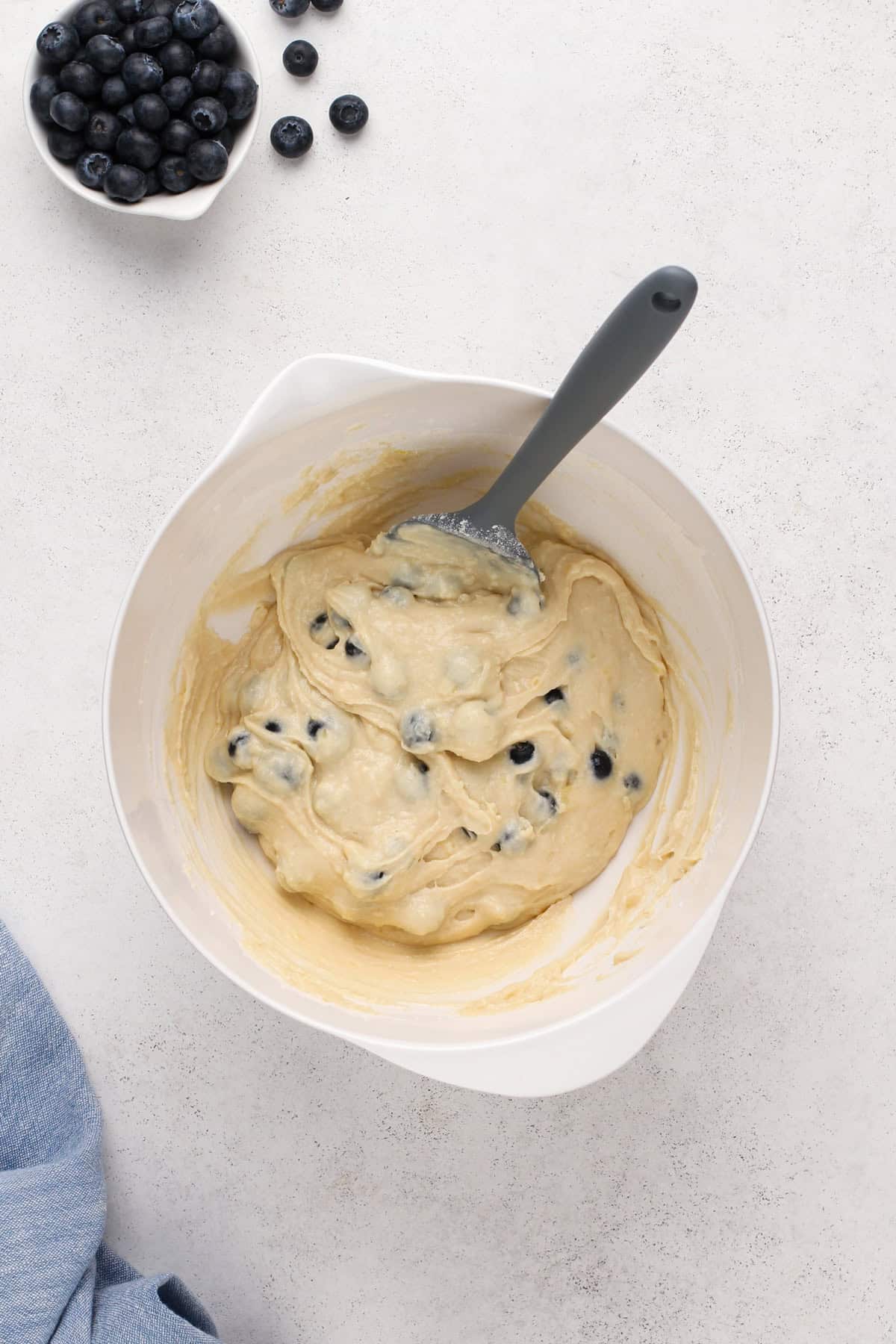 Bisquick blueberry muffin batter in a white bowl.