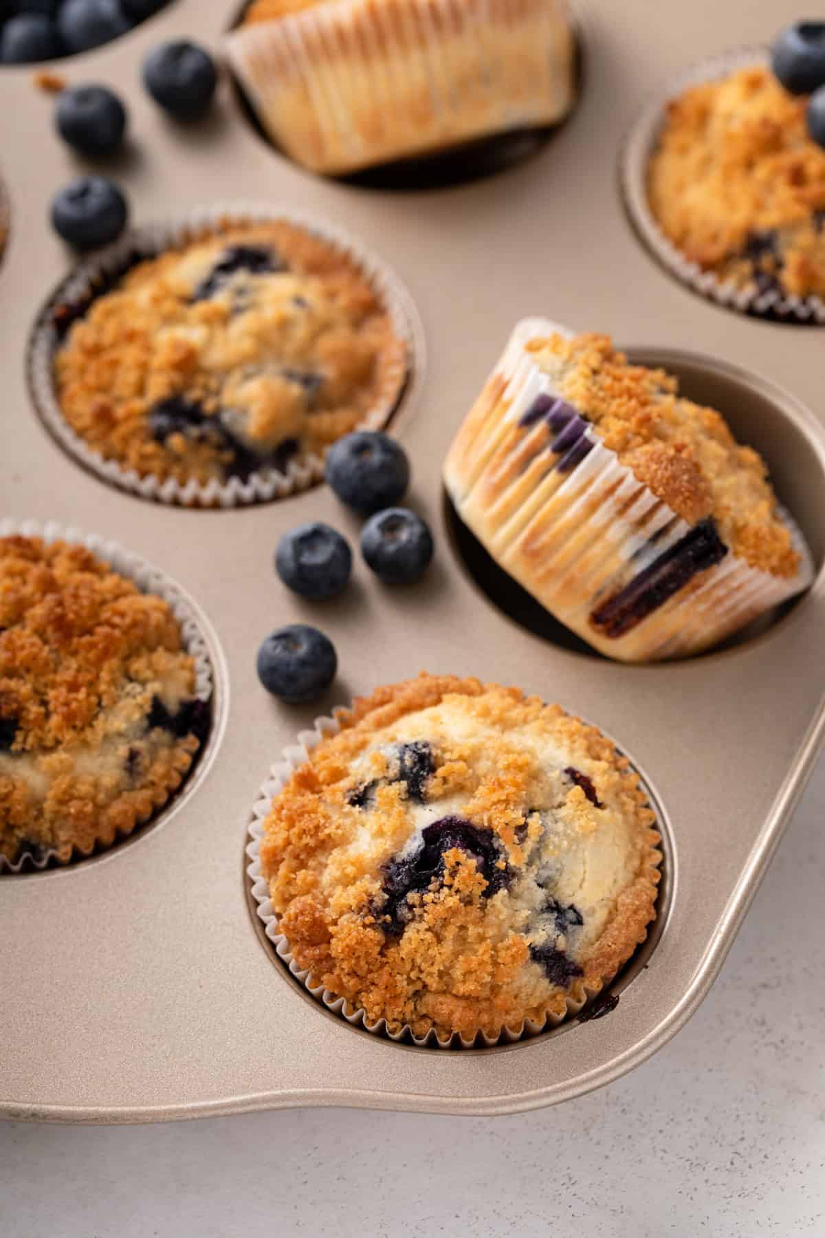Close up of cooled biquick blueberry muffins arranged in a muffin tin.