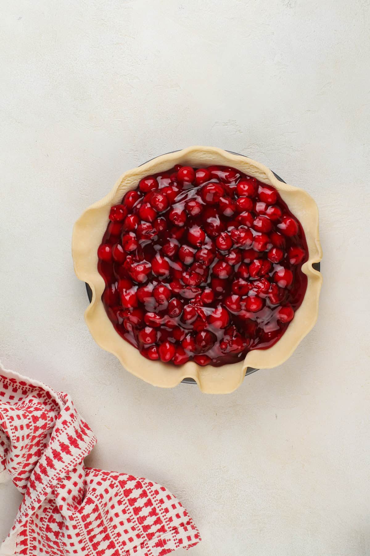 Sour cherry pie filling in a crust-lined pie plate.