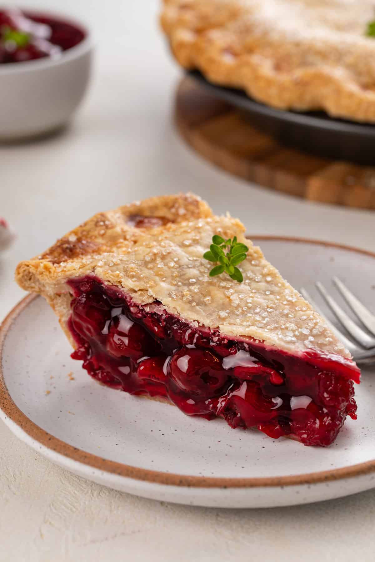Close up of a plated slice of sour cherry pie.