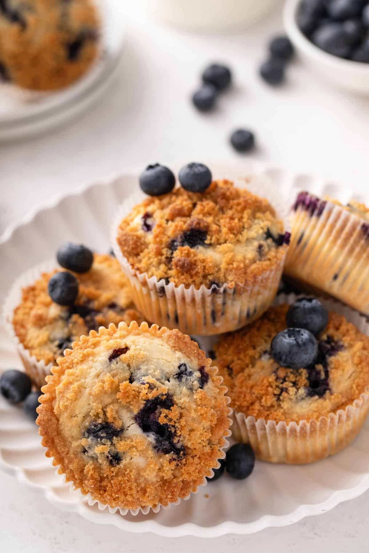 Several bisquick blueberry muffins arranged on a white platter.