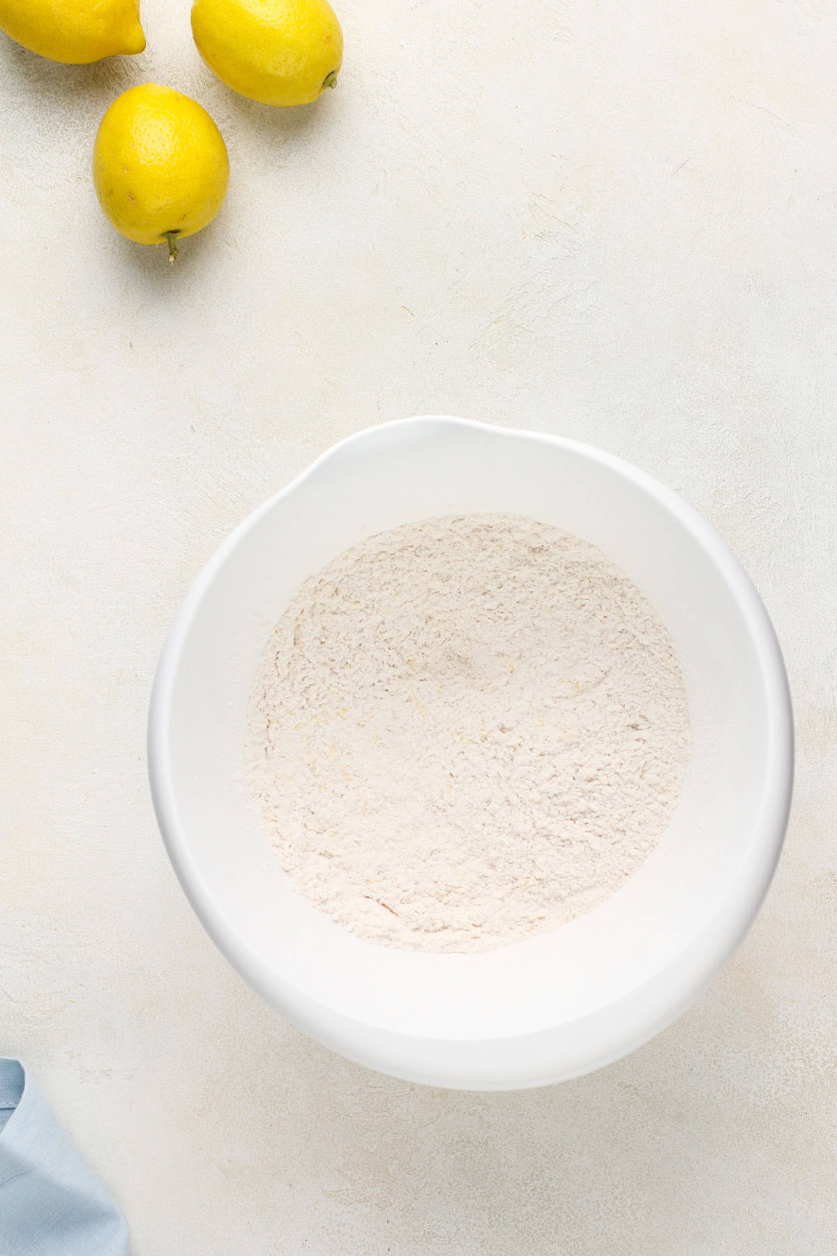 Dry ingredients for lemon scones mixed together in a white bowl.