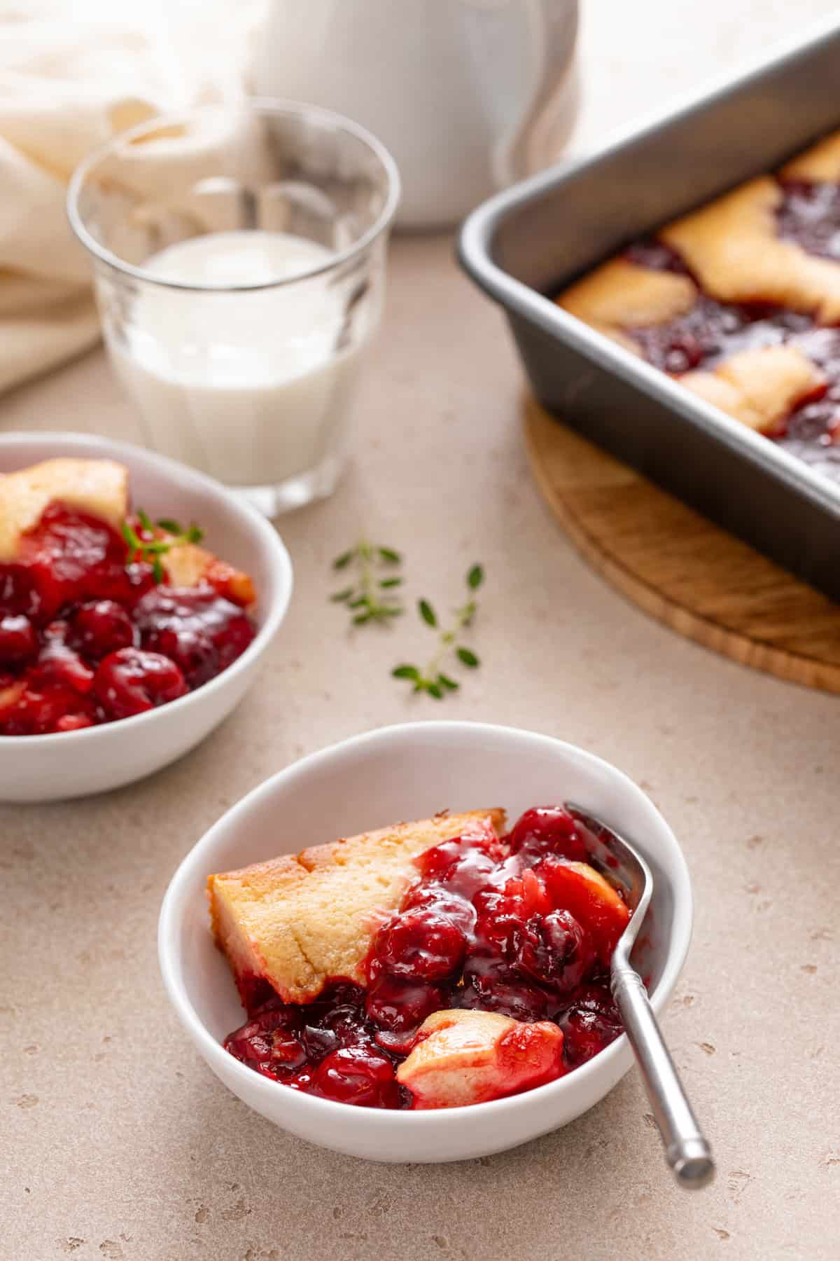 Two white bowls filled with servings of easy cherry cobbler.