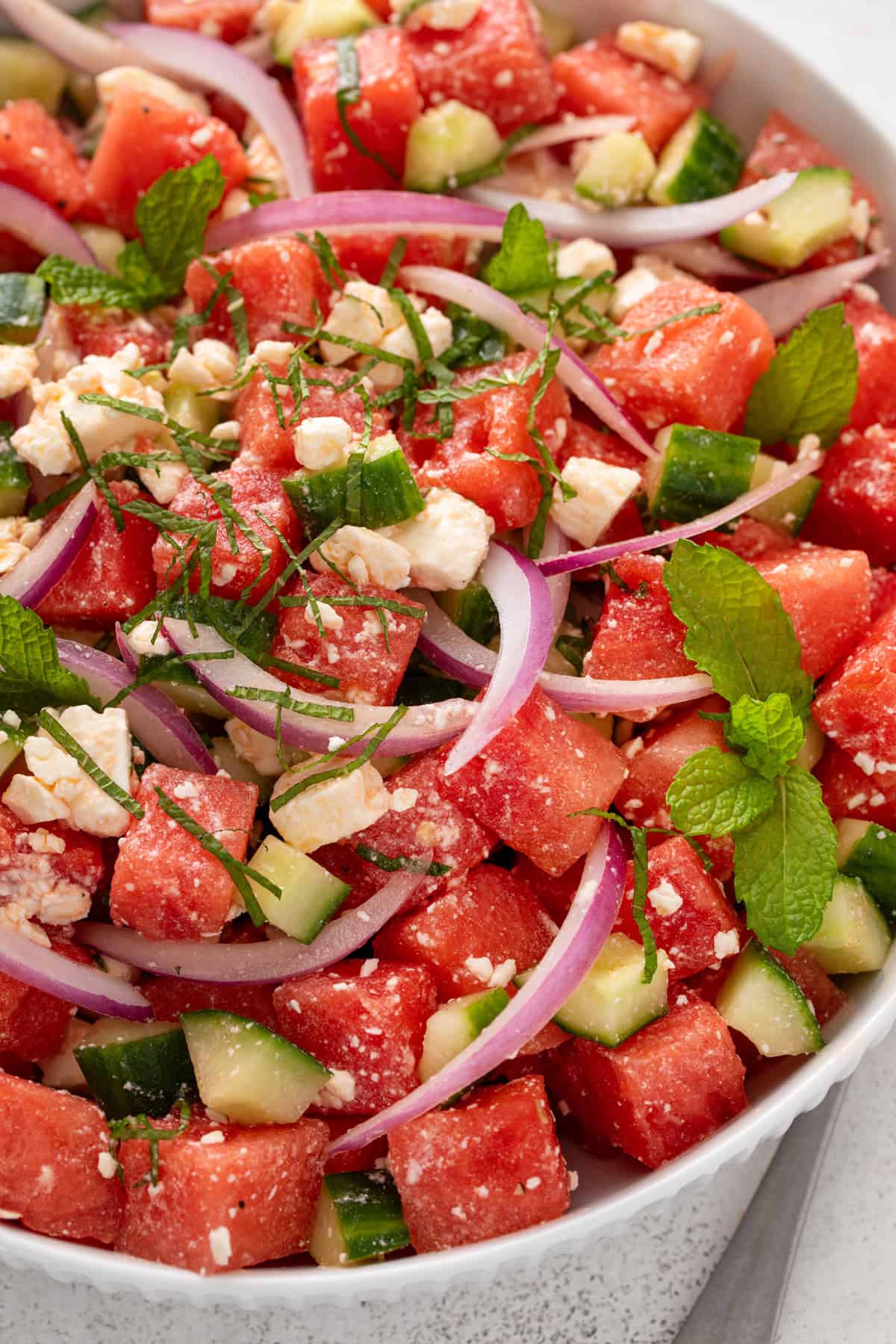 Close up of watermelon feta salad in a white bowl.