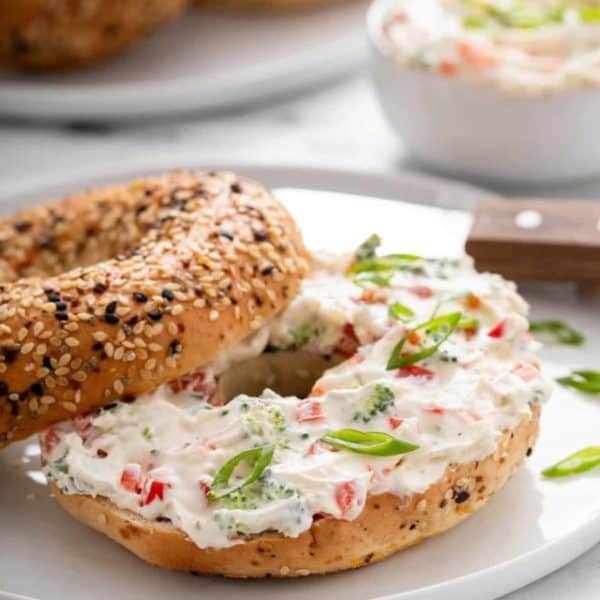 Everything bagel spread with veggie cream cheese on a white plate.