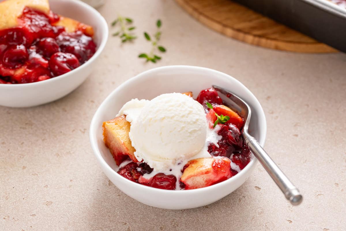 Easy cherry cobbler a la mode in a white bowl.