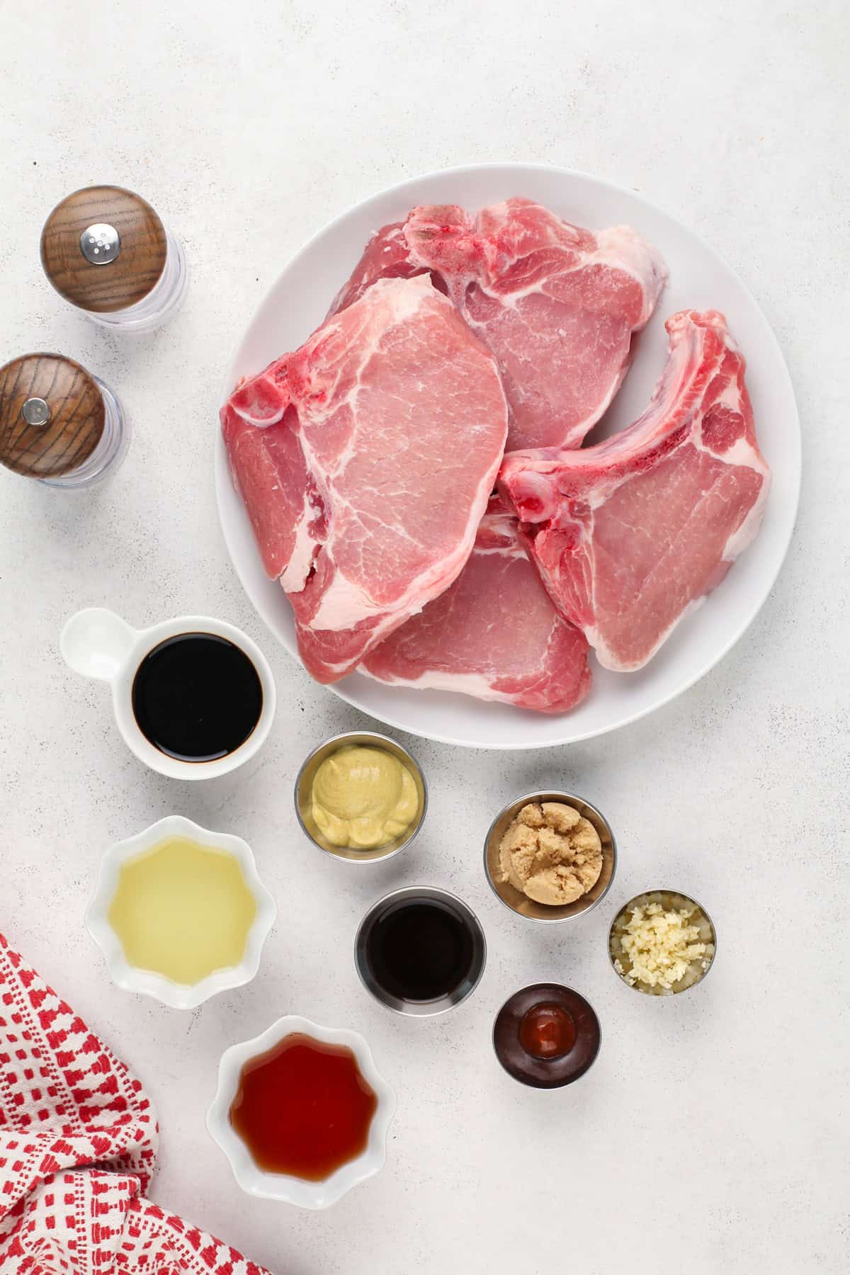 Ingredients for grilled pork chops arranged on a countertop.