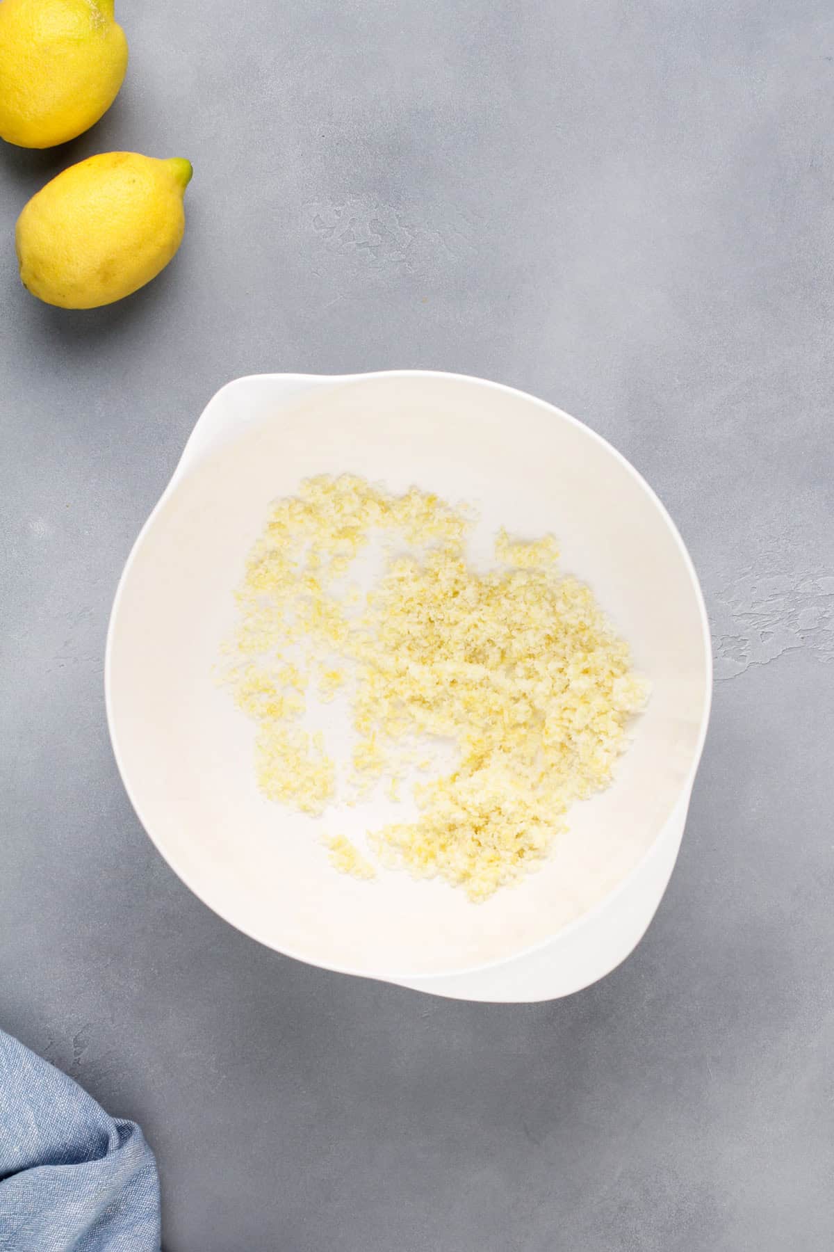 Lemon zest and sugar combined in a white mixing bowl.