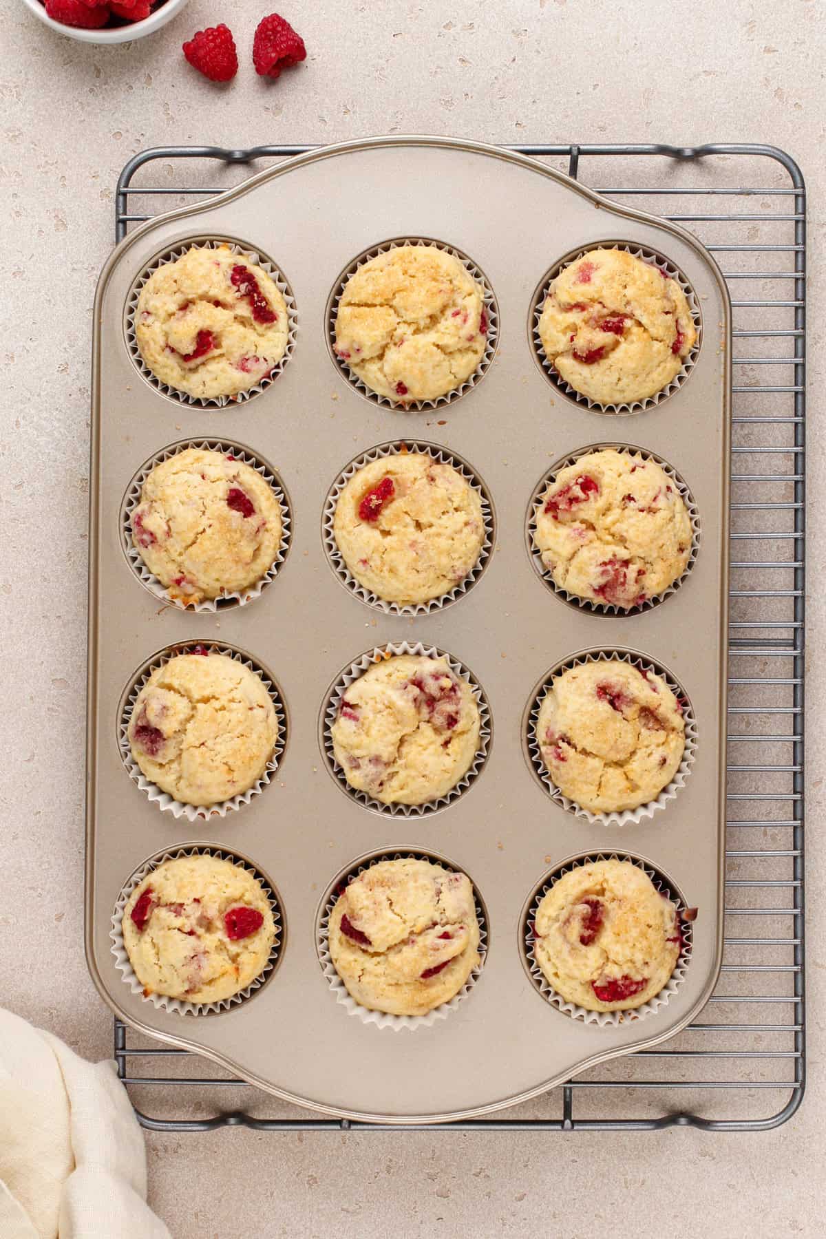 Baked lemon raspberry muffins in a muffin pan.