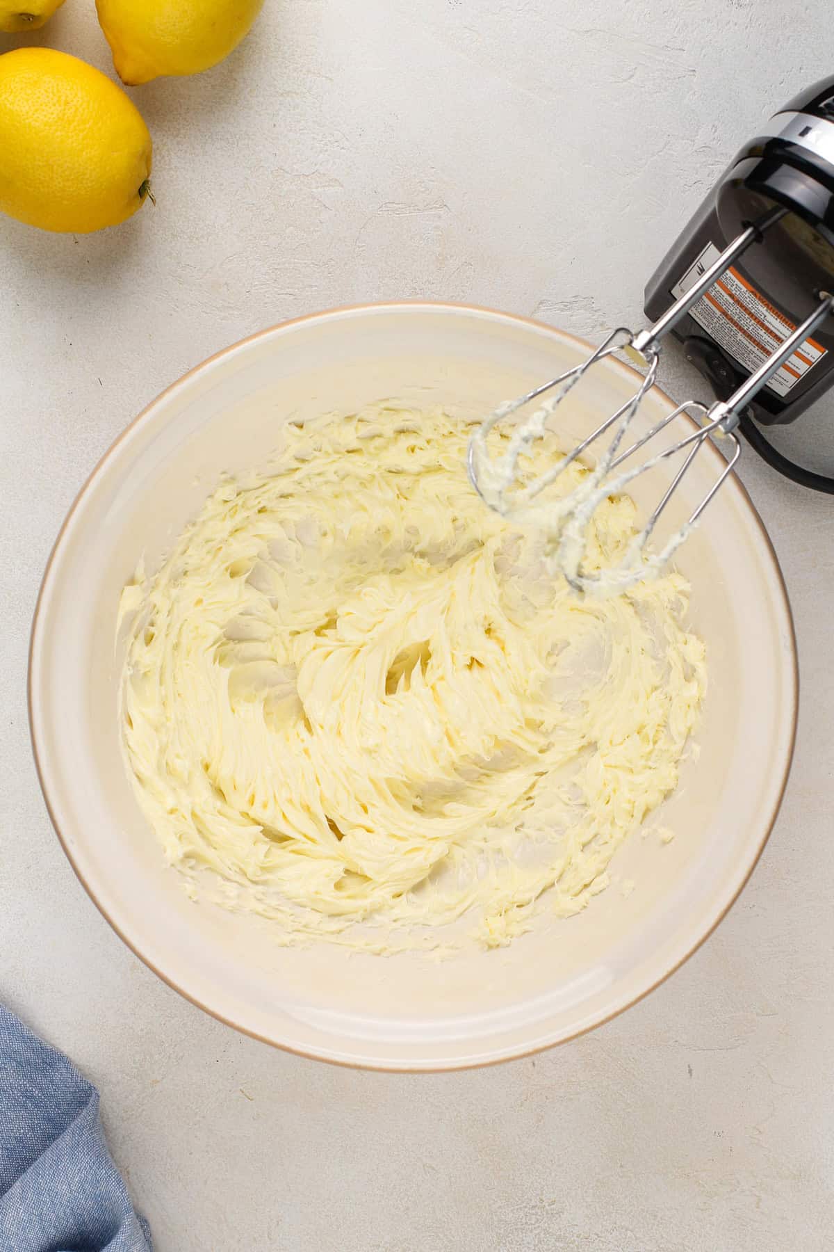 Butter beaten with a mixer in a ceramic mixing bowl.