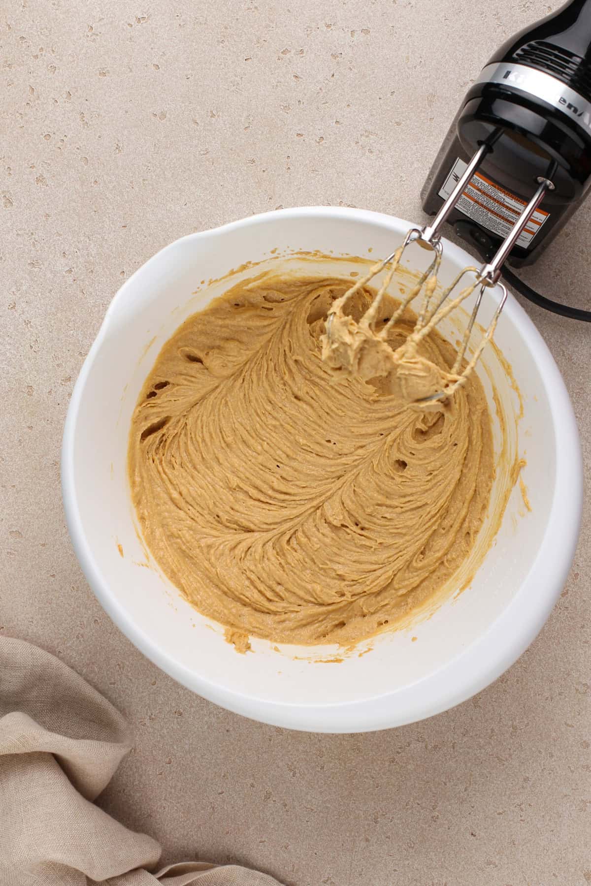 Wet ingredients for peanut butter oatmeal cookies mixed in a white bowl.