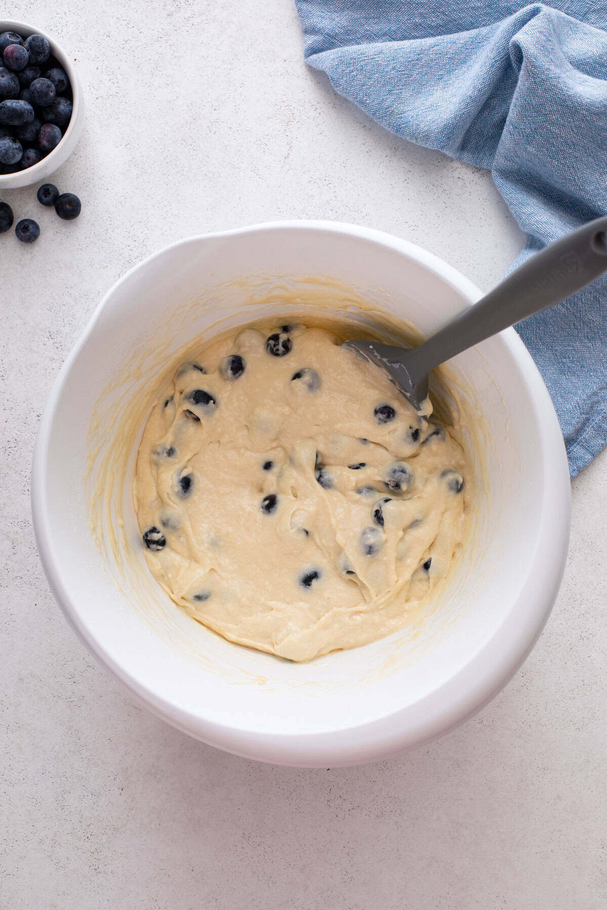 Blueberry pancake batter in a white bowl.