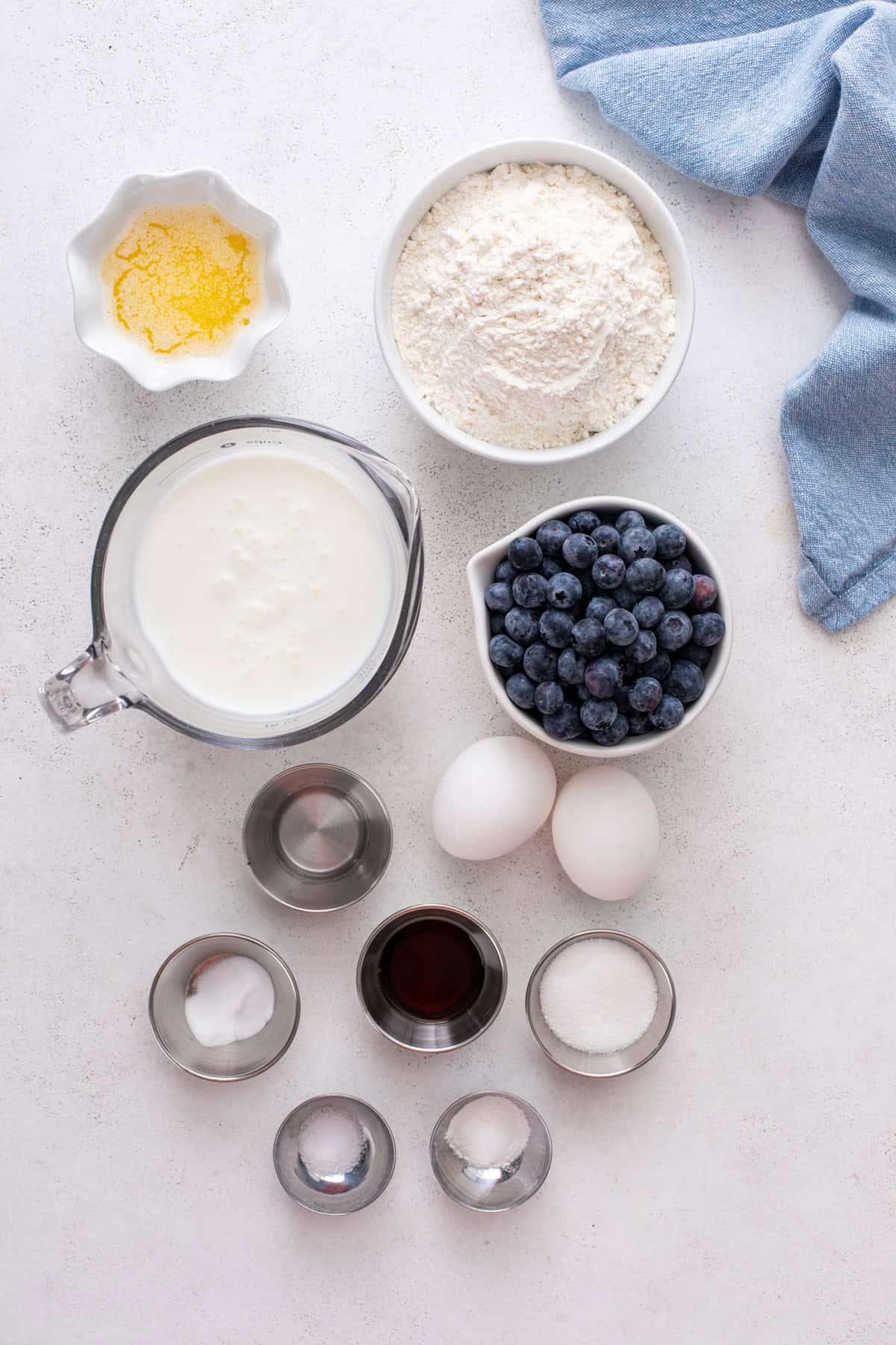Ingredients for blueberry pancakes arranged on a countertop.