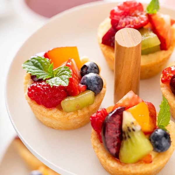 Close up of fruit tarts on a white platter.