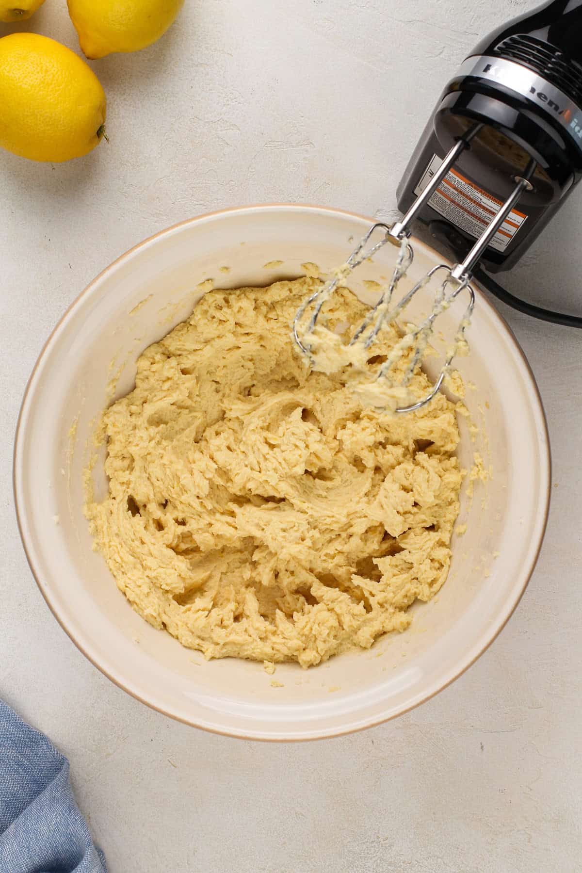 Wet ingredients for glazed lemon cookies in a ceramic mixing bowl.