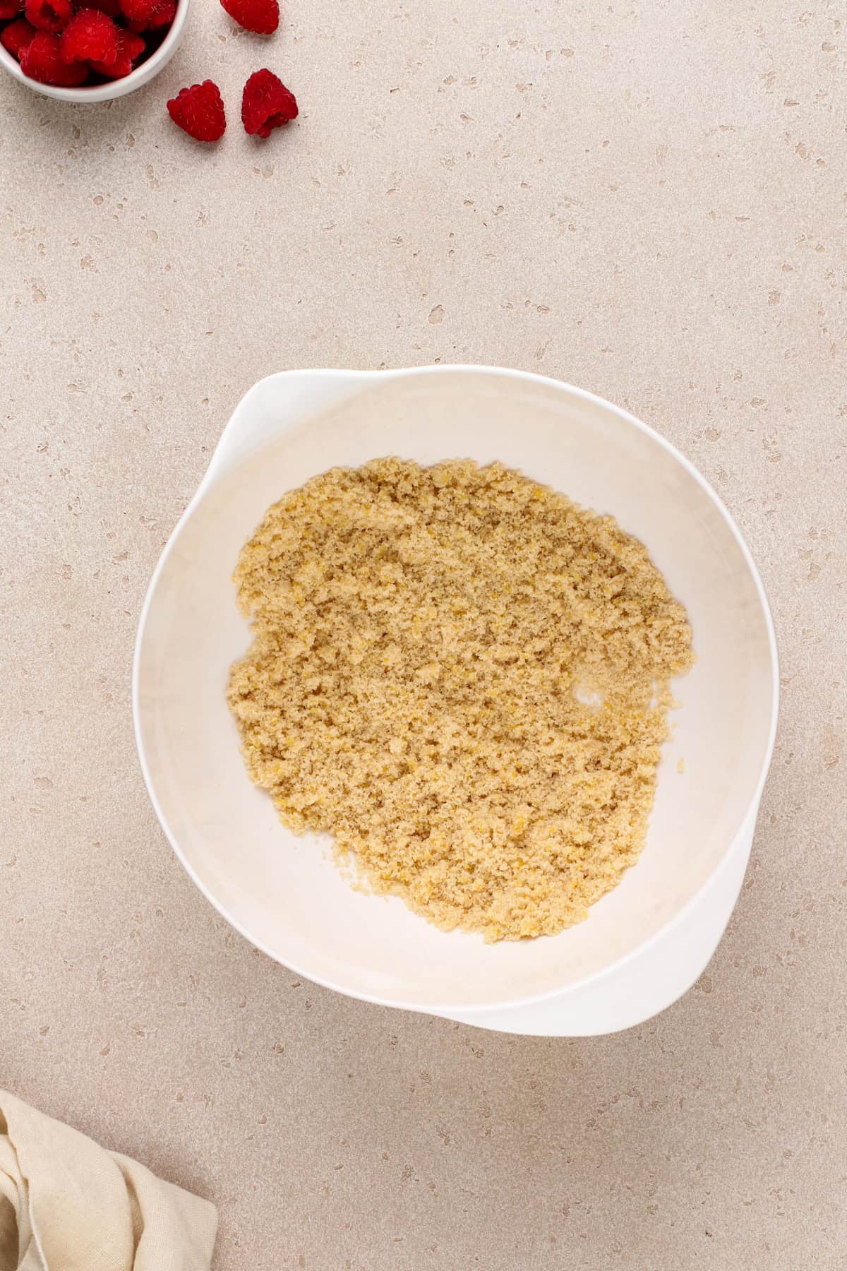 Lemon zest combined with brown and granulated sugars in a large bowl.