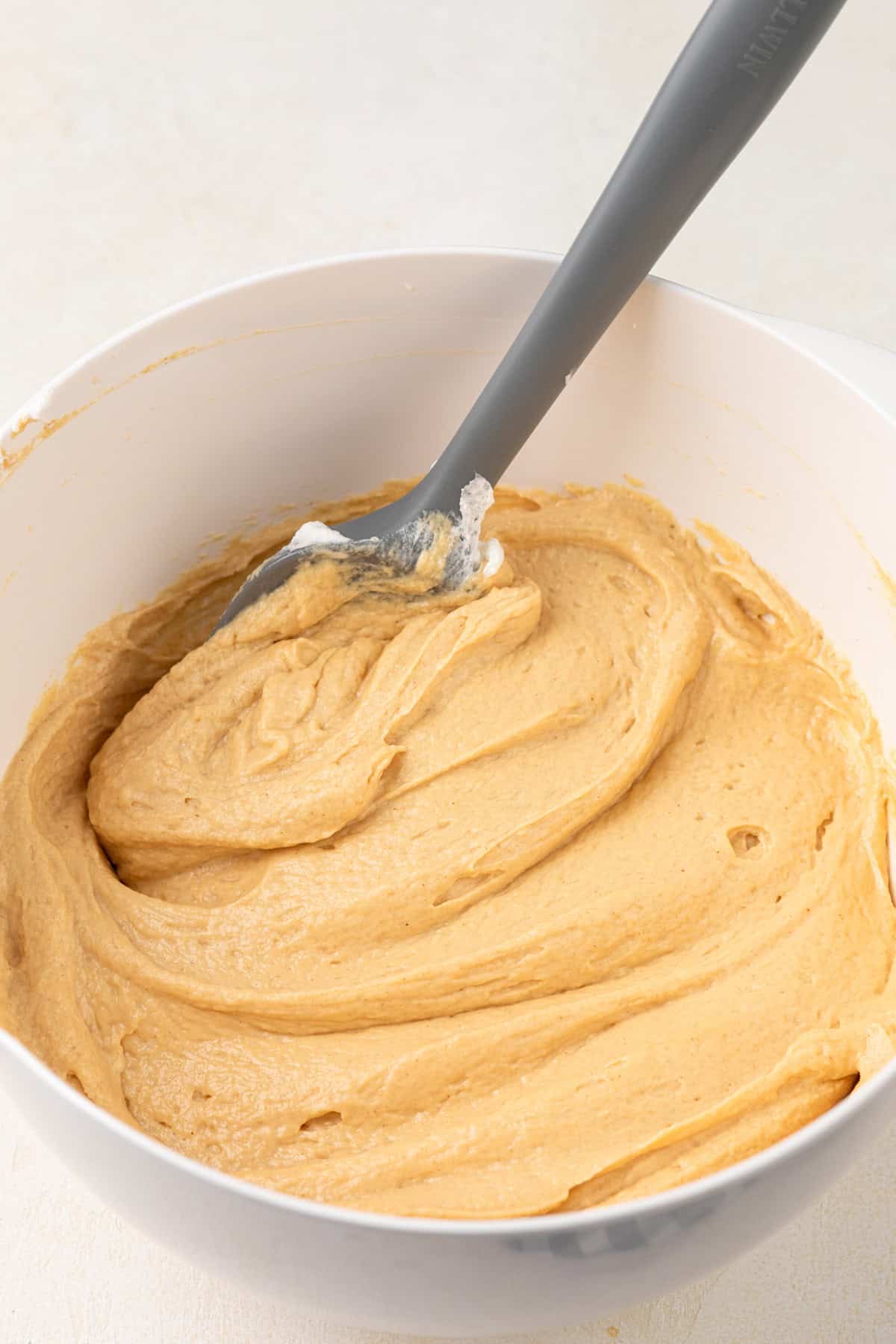 Spatula in a freshly mixed bowl of peanut butter dip.