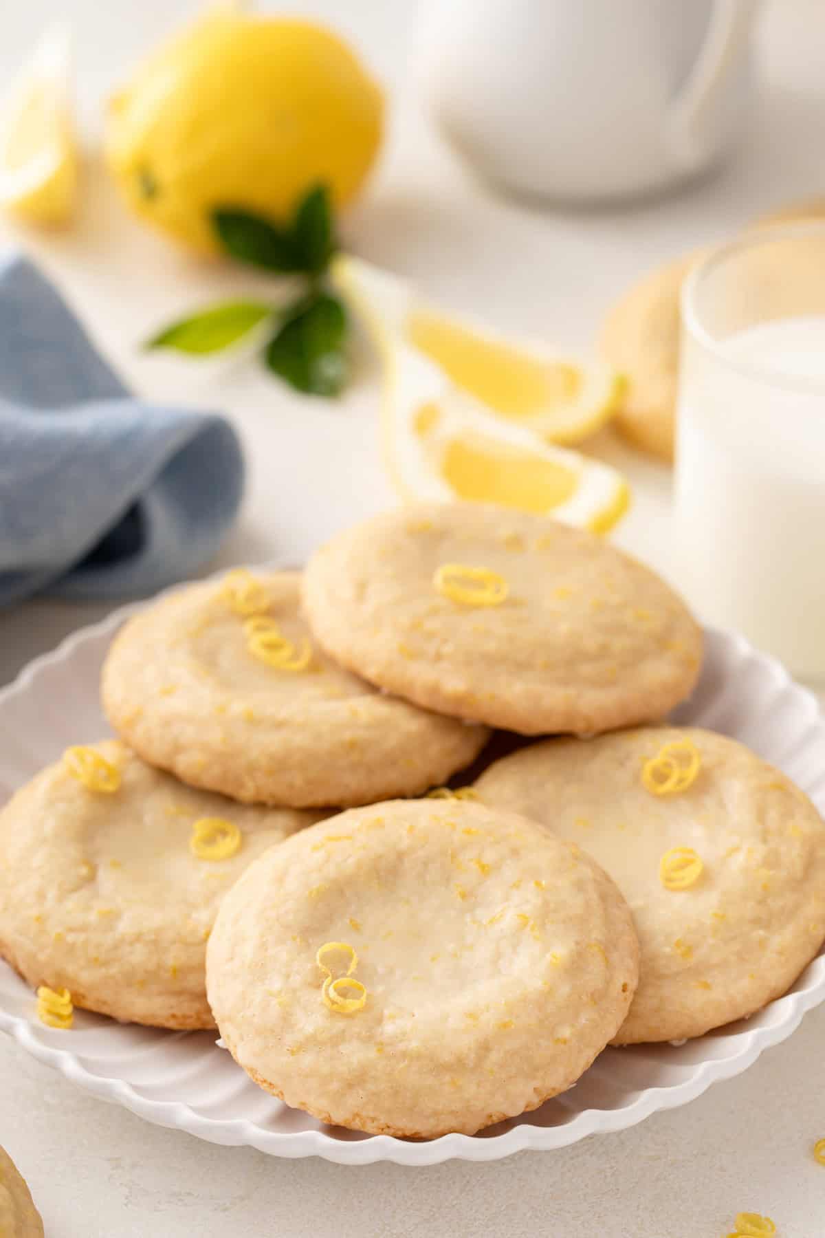 Several glazed lemon cookies arranged on a white platter.