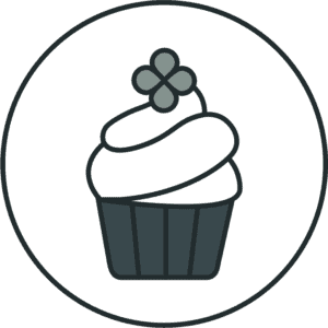 Illustration of a green cupcake topped with white frosting and a green shamrock.