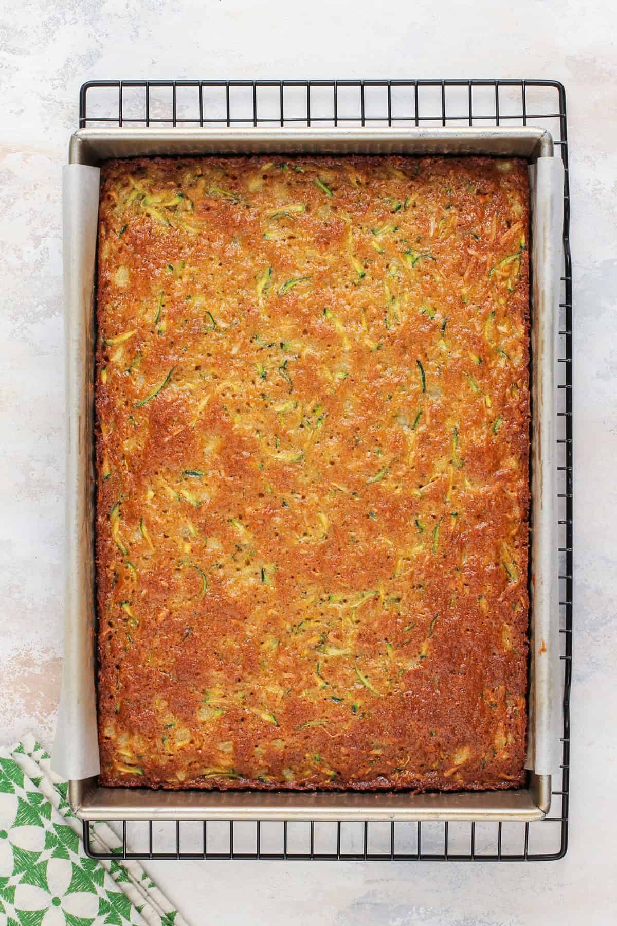 Cooling pineapple zucchini cake in a cake pan.