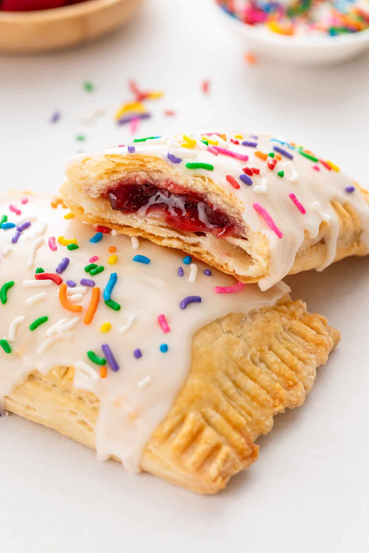 Frosted homemade pop tarts next to a glass of milk.