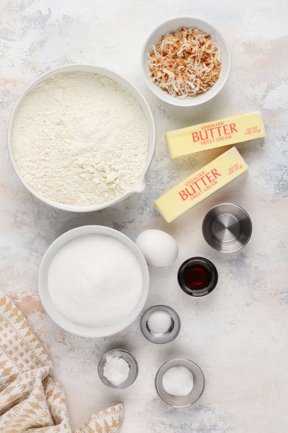 Ingredients for coconut sugar cookies arranged on a countertop.