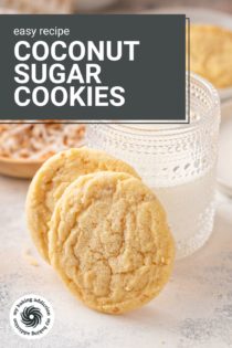 Two coconut sugar cookies leaning against a glass of milk. Text overlay includes recipe name.