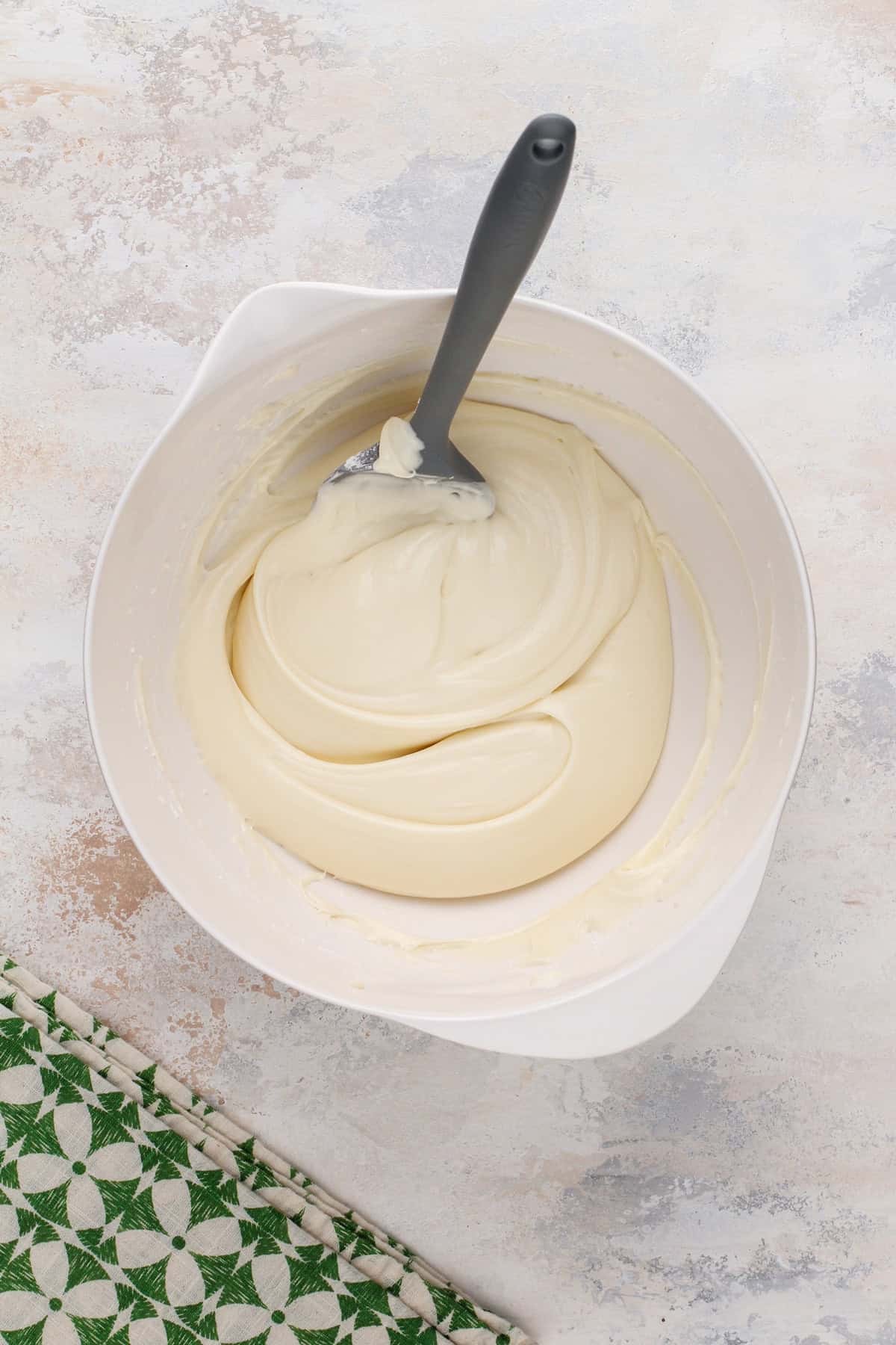 Cream cheese frosting in a white bowl.