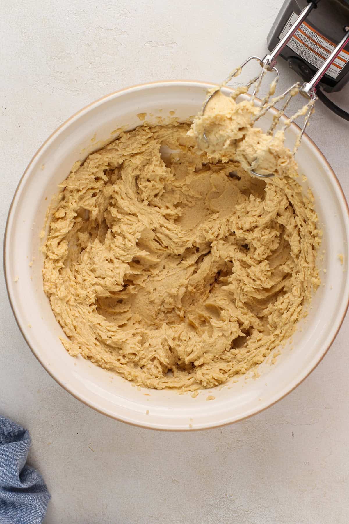 Wet ingredients for heath bar cookies mixed in a ceramic mixing bowl.