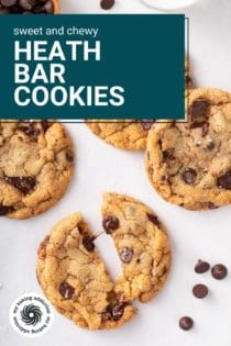 Several heath bar cookies on a countertop. One cookie is cut in half to show the gooey chocolate chips. Text overlay includes recipe name.