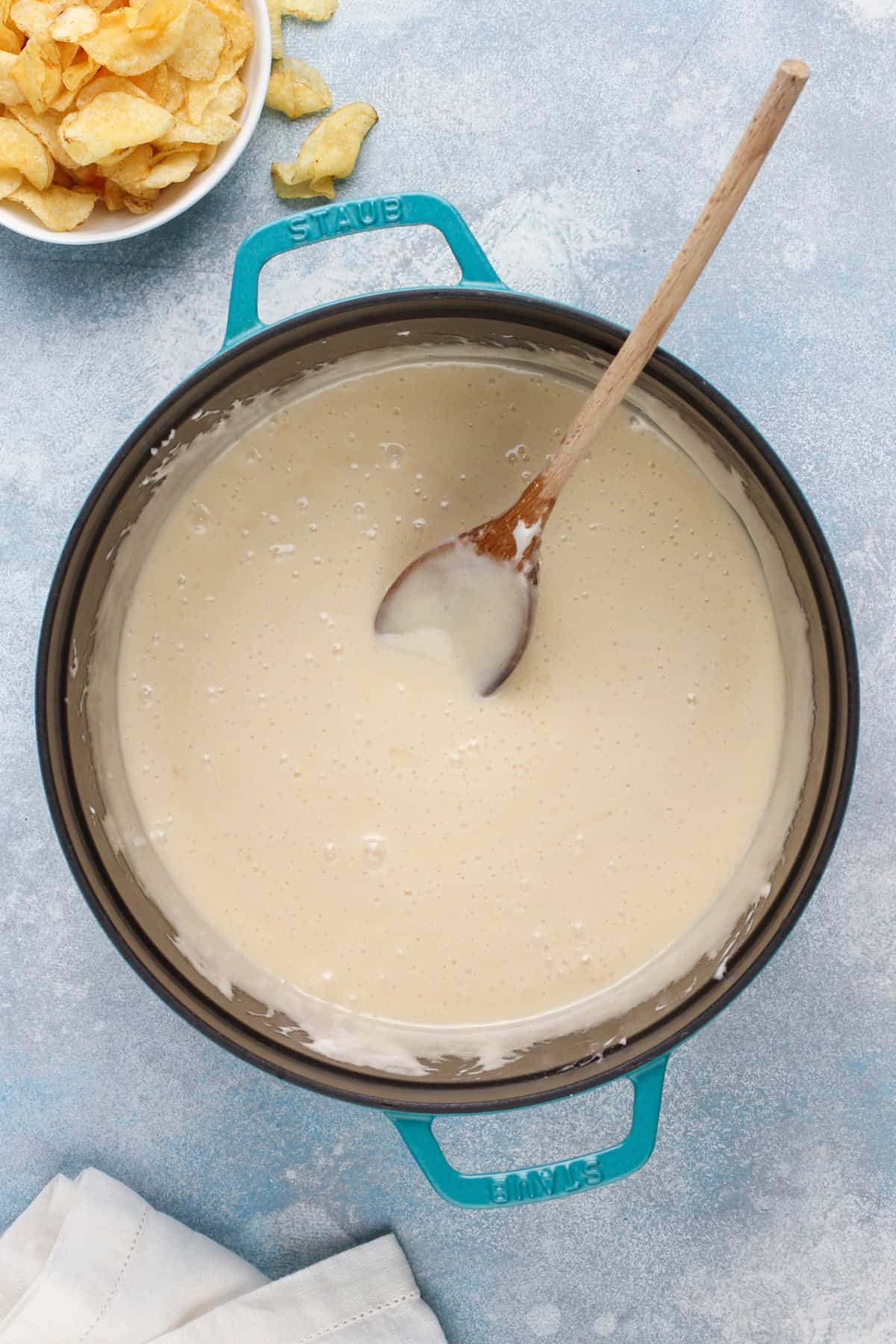 Melted butter and marshmallow mixture in a blue dutch oven.