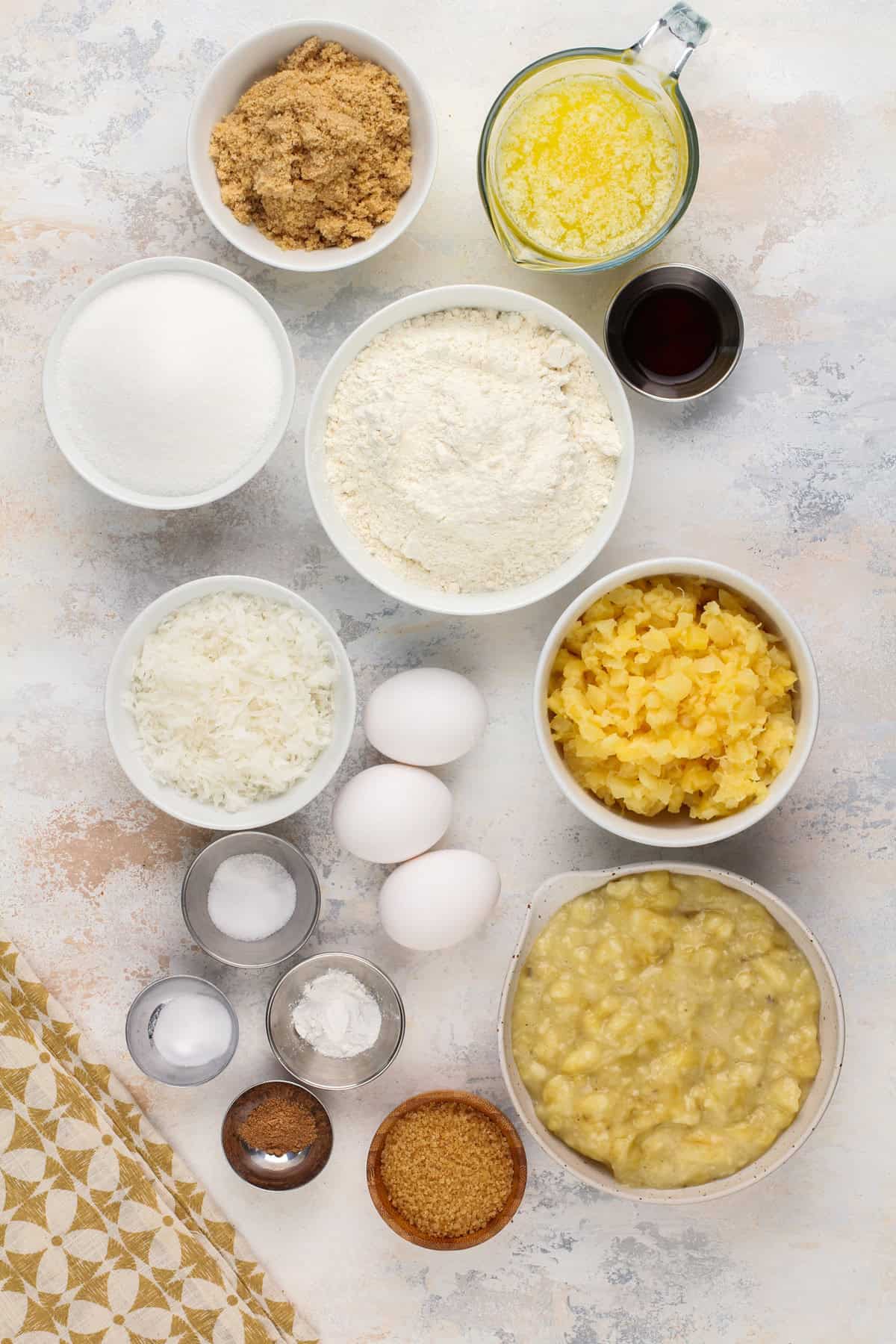 Ingredients for pineapple banana bread arranged on a countertop.