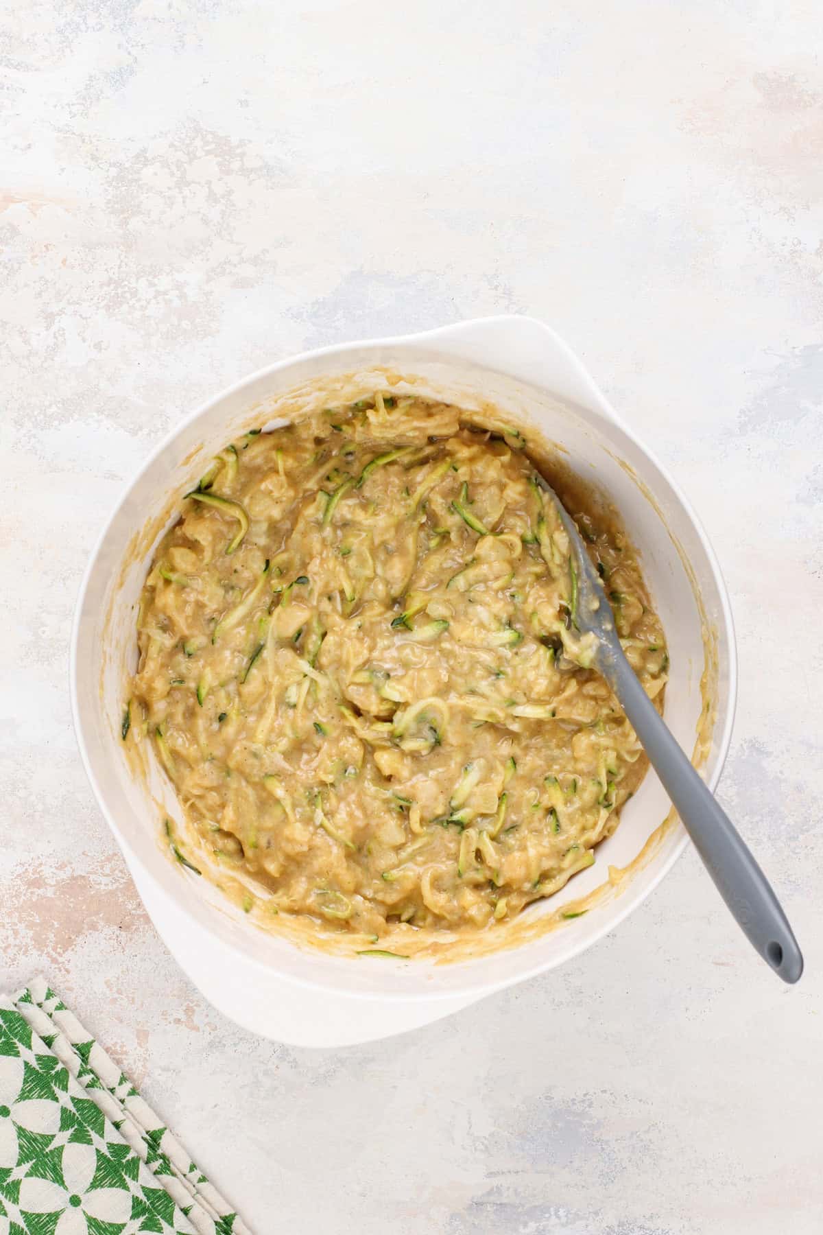 Pineapple zucchini cake batter in a white bowl.