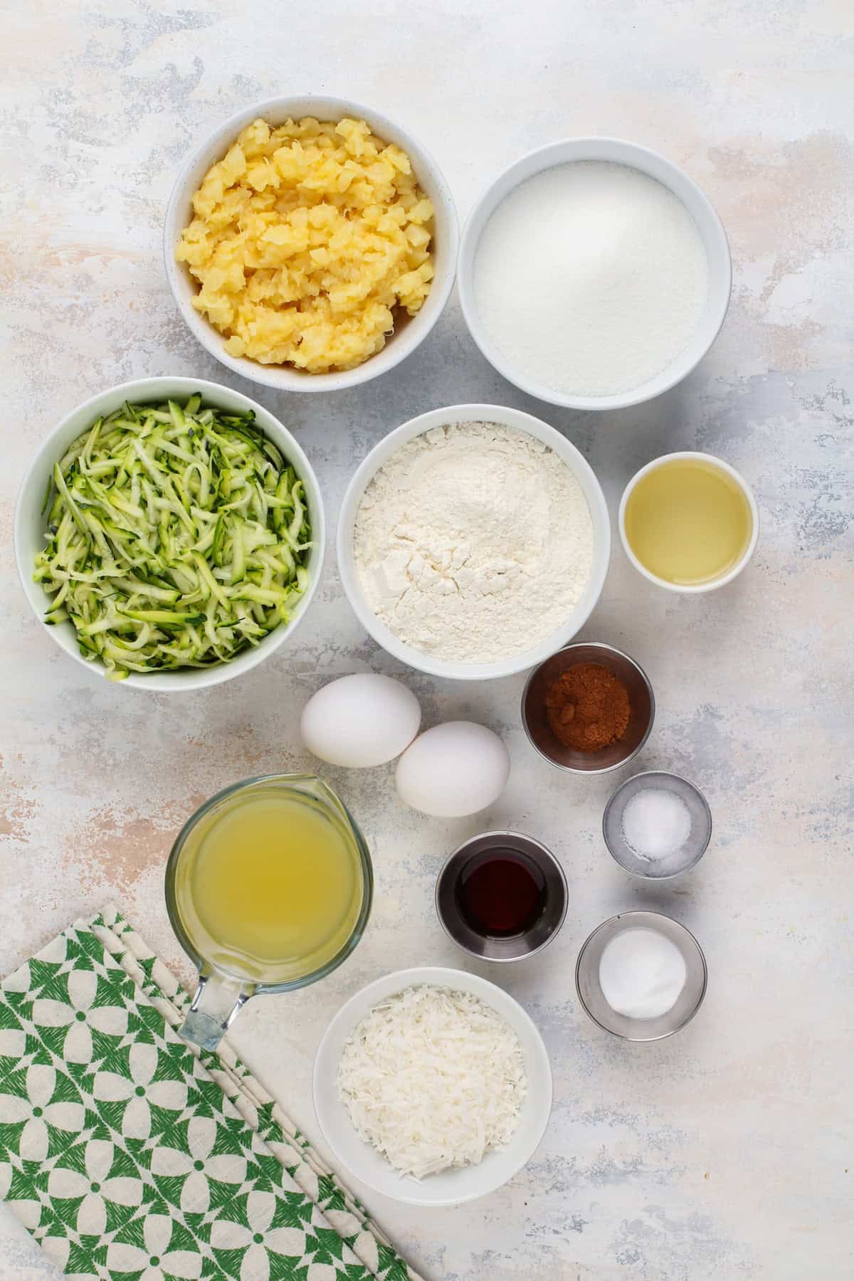 Pineapple zucchini cake ingredients arranged on a countertop.