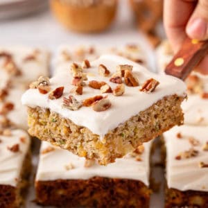 Cake server holding a slice of pineapple zucchini cake.