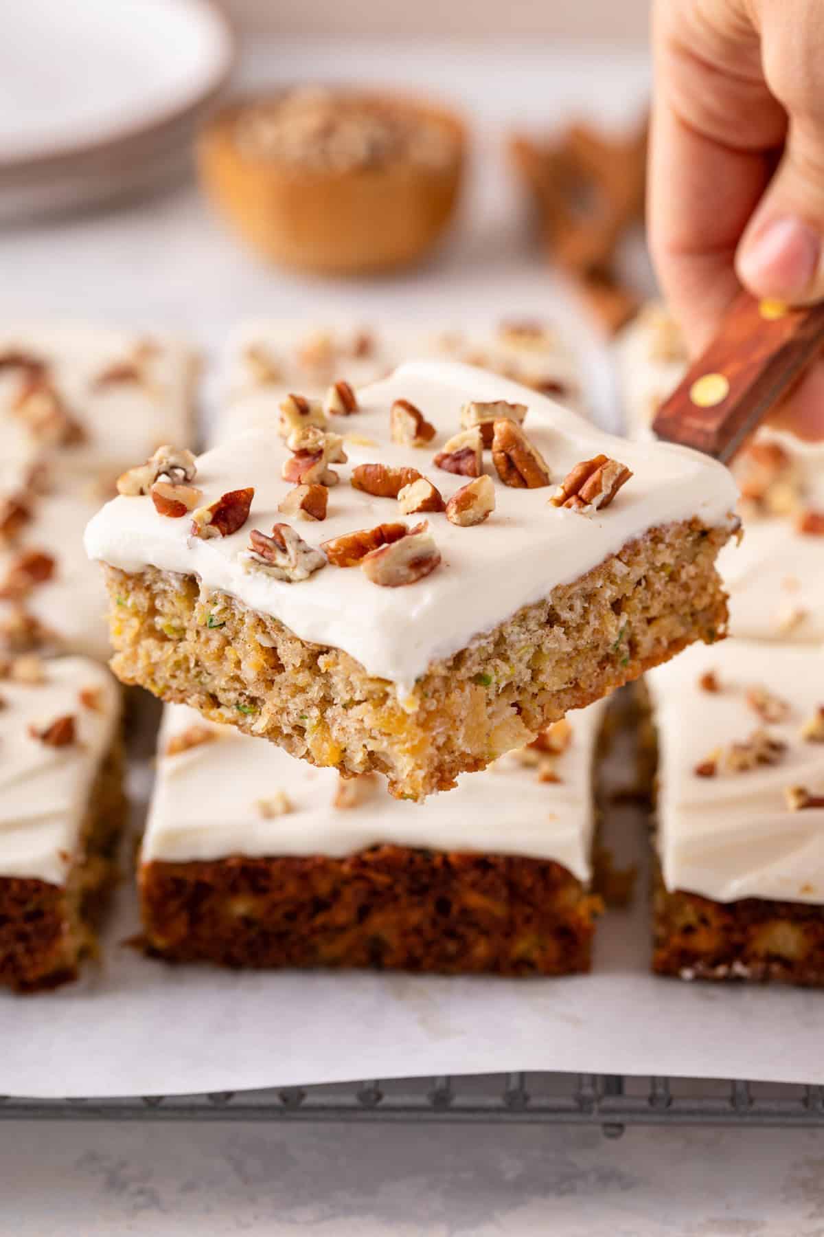 Cake server lifting up a slice of pineapple zucchini cake.