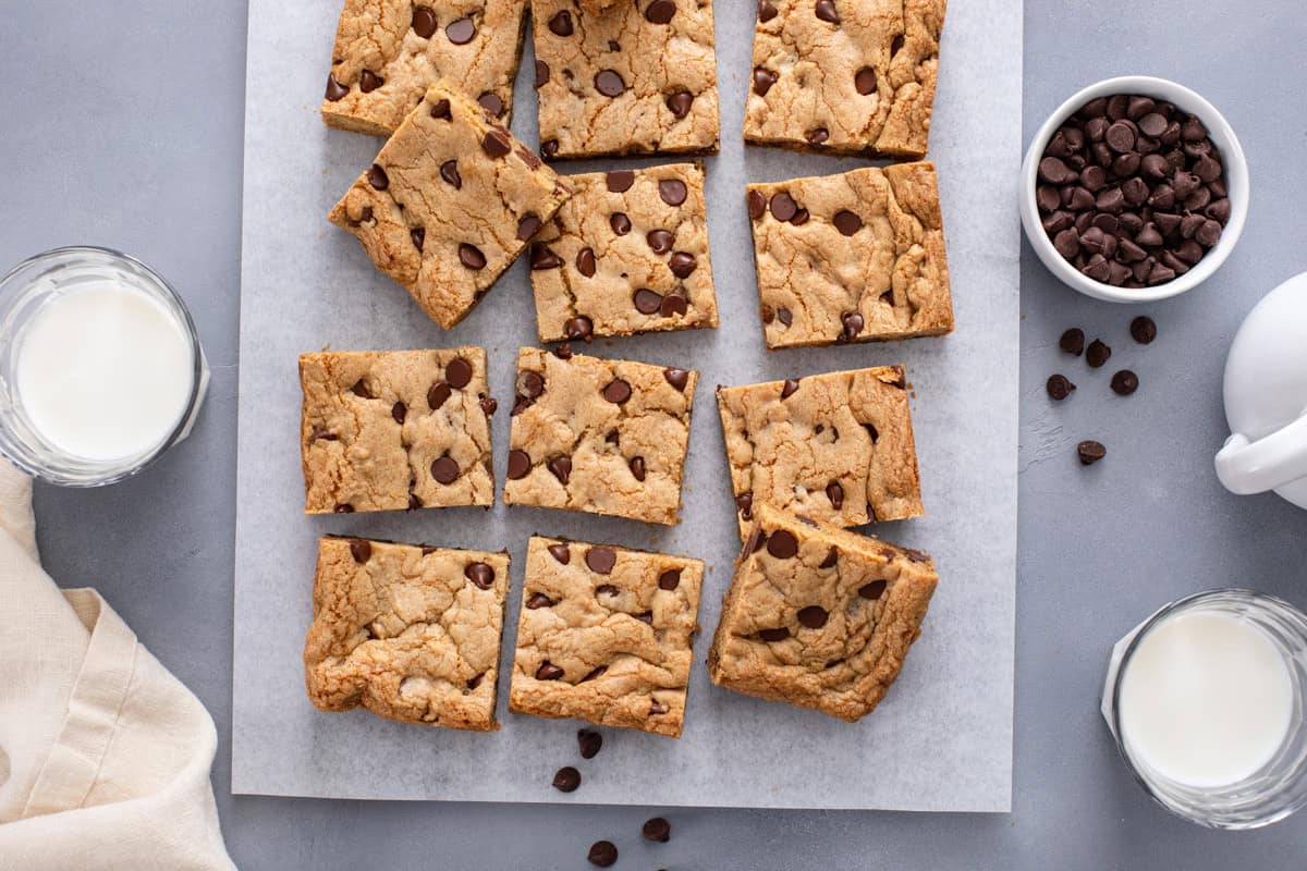 Overhead view of sliced chocolate chip cookie bars on a piece of parchment paper.