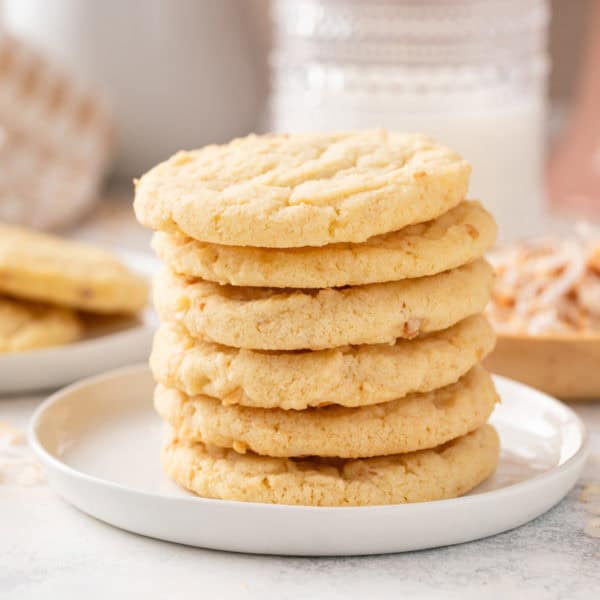 Coconut sugar cookies stacked on plate.