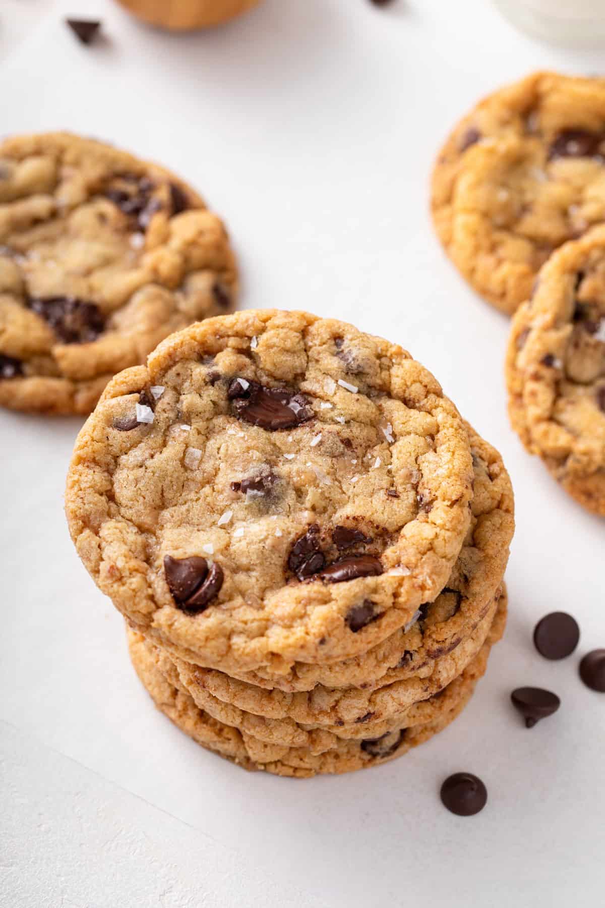 Several heath bar cookies stacked on a countertop.