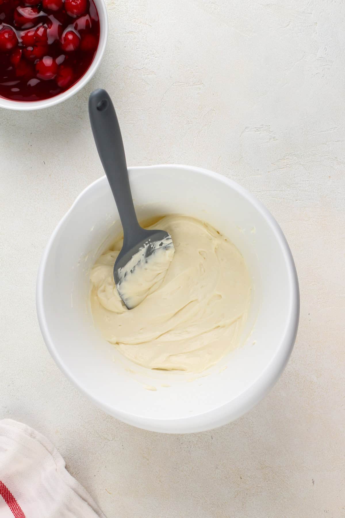 Beaten cream cheese in a white mixing bowl.