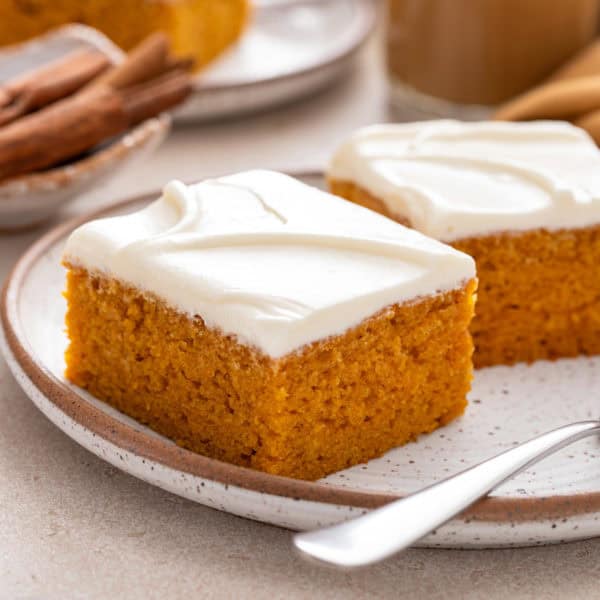 Two frosted pumpkin bars on a plate.