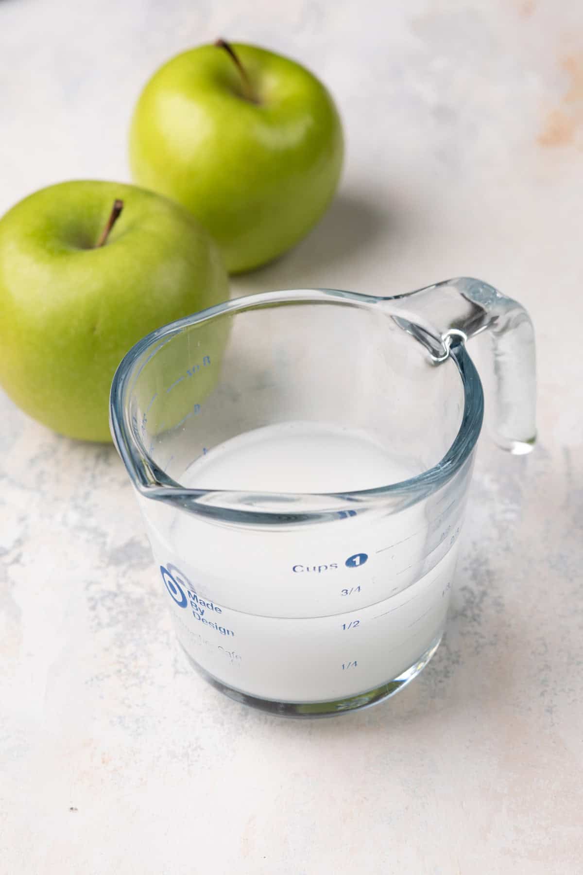 Cornstarch slurry in a glass measuring cup.